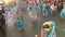 Young women in ornate butterfly costume dance along the street, a festival to honor a patron saint