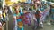 Young women in ornate butterfly costume dance along the street, a festival to honor a patron saint