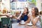 Young women paying for coffee at street cafe