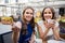 Young women paying for coffee at street cafe