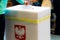 Young women puts voting card to box in Polish regional ellection referendum