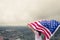 Young women raise national american flag against the blue sky. Independence Day, 4th July