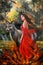 A young women in red burning dress stand with a deer against the forest. Oil painting.