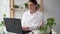 Young women scientist working on a laptop computer, making analysis of a lab-grown food. Microbiologist working in