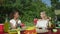 Young women sits at the table, eats vegetables, drinks and waits for bbq