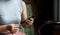 Young women sitting on the chair playing with smartphone While charging the smartphone battery and device Charge Sharing