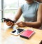 Young women sitting on the chair playing with smartphone While charging the smartphone battery and device Charge Sharing