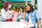 Young women sitting with shopping bag and girl using smartphone behind in shopping mall, young girls shopping concept