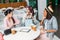 Young women sitting at table with paper cups and showing new stylish shoes, young girls shopping concept