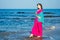 Young women wearing a pink blue saree on the beach goa India.girl in traditional indian sari on the shore of a paradise