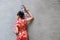 Young women wearing red Chinese dress welcome the new year holding a fan