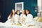 Young women in white bathrobe with champagne glasses at a spa party