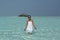 Young women in a white dress standing in turquise water Maldives