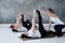 Young women working out doing exercise on floor in Supta Padangushthasana