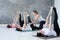 Young women working out doing exercise on floor in Supta Padangushthasana