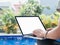 Young women working by the swimming pool. Female remote worker writing code, study, surfing internet during summer. Close up of ha