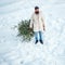 Young woodcutter winter portrait. Christmas lumberjack with axe and Christmas tree. Santa Claus with Christmas tree