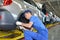 The young worker on the assembly conveyor of automobile plant