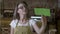 Young worker cafe shop girl flipping over open close green screen sign and looking outside for customers -