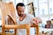 Young worker in a carpenters workshop with wooden chair