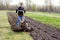 Young worker cultivates the soil