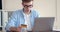 Young worker doing financial transaction with credit card and laptop