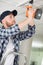 Young worker drilling ceiling