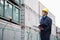 Young worker in protective work wear examining cargo in a shipping yard