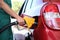 Young worker refueling car at modern gas station, closeup