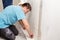 Young worker smoothing wallpaper in the room