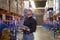 Young worker wearing helmet checking inventory and counting product on shelf in modern warehouse