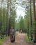 A young Yakut Asian girl with a package in her hands in protective clothing smiles on the road in the forest