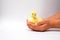 Young yellow Duckling in black tanned child hands on white