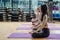 Young yoga practitioners in group doing yoga in modern fitness class indoor