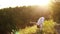 Young yoga woman trainer Standing Forward Bend with Shoulder Opener in evening at sunset.