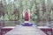 Young yogi  girl  practicing yoga, sitting in variation of Gomukhasana, Cow Face Posture  on the pier of a beautiful lake. Concept