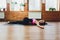 Young yogi sporty woman working out, warming up using yogic belt, lying in yoga Supta Padangushthasana, One Leg Lift