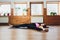 Young yogi sporty woman working out, warming up using yogic belt, lying in yoga Supta Padangushthasana, One Leg Lift
