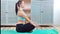 Young yogi woman practicing yoga sitting in namaste asana lotus pose full shot