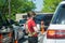 Young youthful fast food worker working at Chick-fil-a drive through amidst cars take orders with tablet