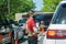 Young youthful fast food worker working at Chick-fil-a drive through amidst cars take orders with tablet