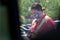 Young youthful fast food worker working at Chick-fil-a drive through amidst cars take orders with tablet