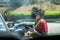 Young youthful fast food worker working at Chick-fil-a drive through amidst cars take orders with tablet