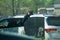 Young youthful fast food worker working at Chick-fil-a drive through amidst cars take orders with tablet