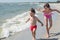 The younger brother and older sister play flying planes on the seashore