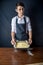 Youngman chef in uniform black apron prepares the dough for baking the cake. Concept of men cook desserts