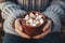 A youngster& x27;s hands embracing a warm cup of cocoa adorned with fluffy marshmallows, radiating the happiness of