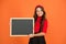 For your attention. Happy girl hold blackboard orange background. Small kid with blank blackboard. Little schoolchild