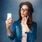 When youre feeling cute, youve gotta take a selfie. Studio shot of a beautiful young woman taking a selfie against a