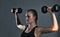 Youre only getting stronger. Studio shot of a sporty young woman building muscle in her arms.